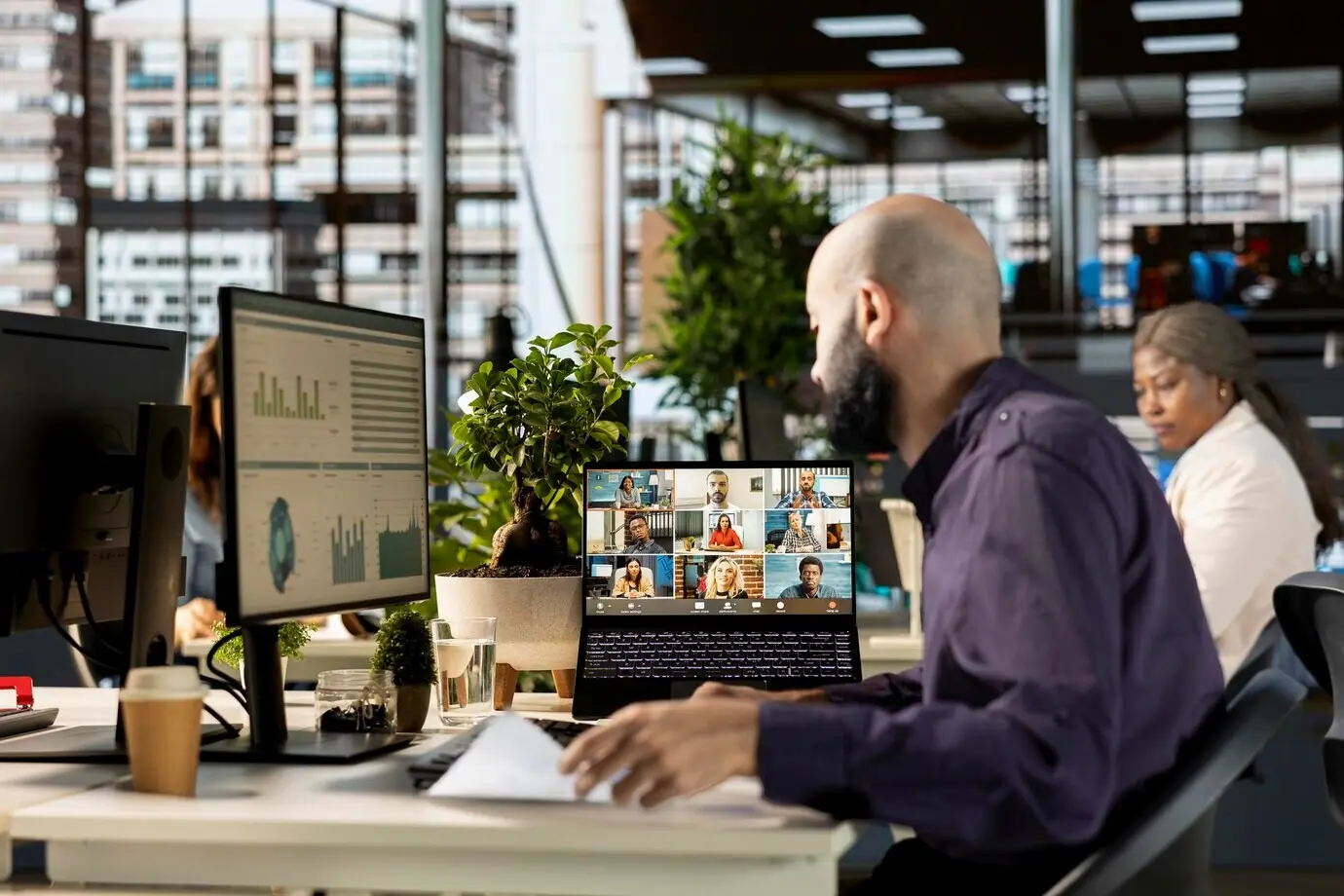 A Middle Eastern employee joins a video meeting with members of the executive board.